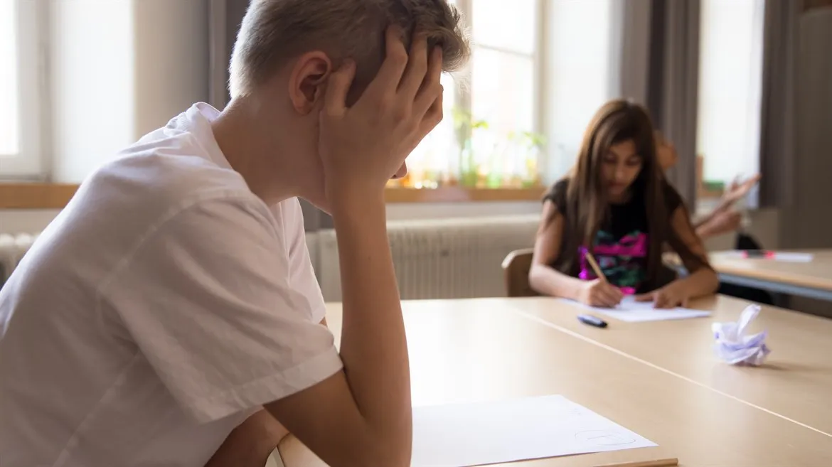 Pojke kämpar med prov i skolan