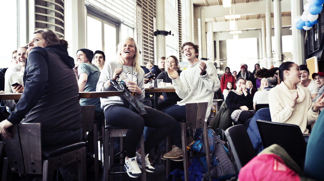 Studenter i Ljushallen som tittar på skidåkning. 