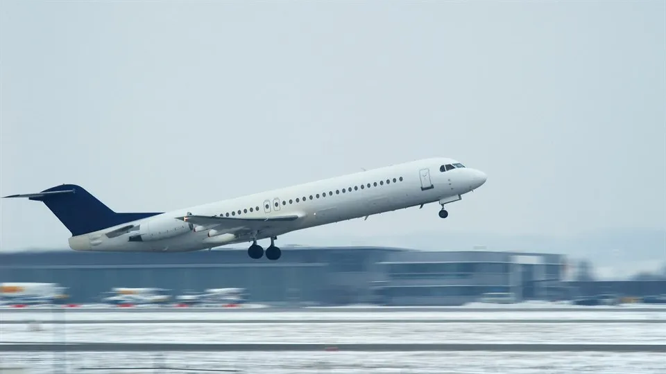 Airplane about to take of from a wintery airport.