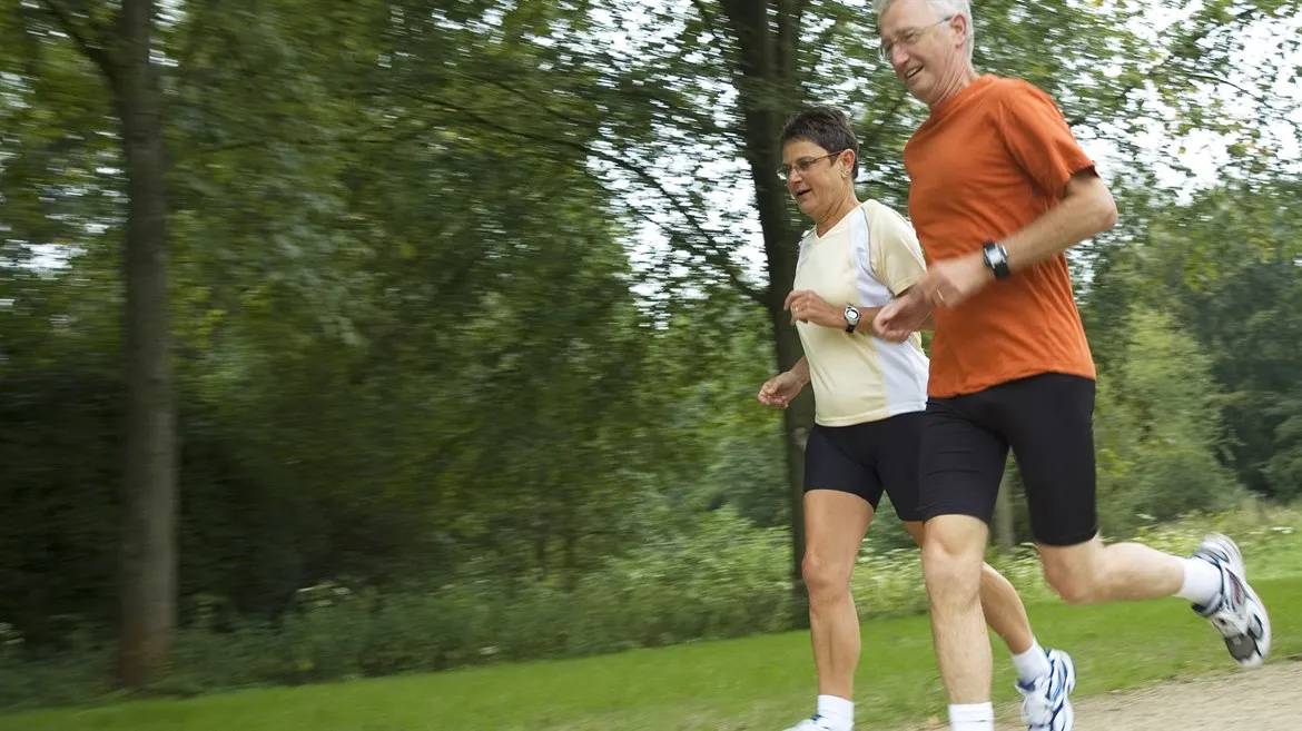 man och kvinna joggar i naturen