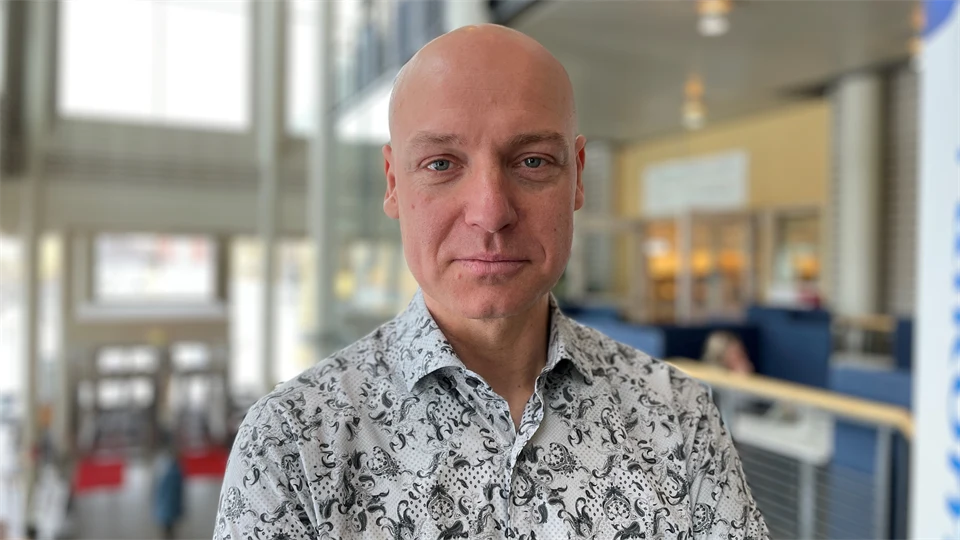 En medelålders man i mönstrad skjorta.