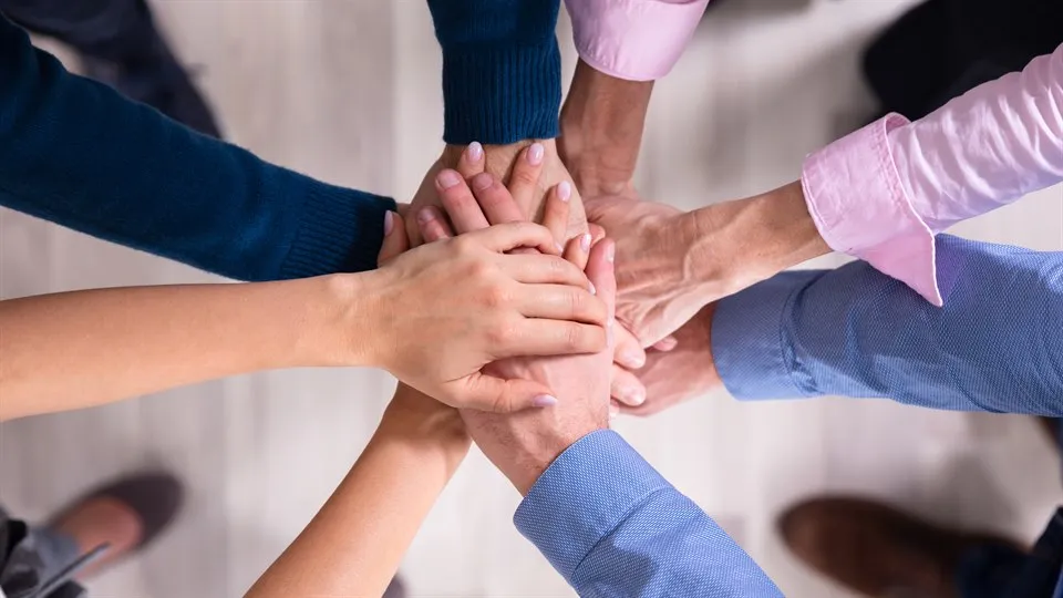 Businesspeople Stacking Hands Over Each Other